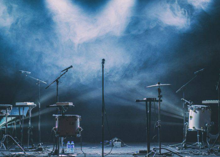 A stage at a live performance. The instruments and mics are surrounded by atmospheric smoke.